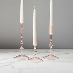 three candles are sitting on a marble table