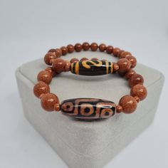 Agate Tibetan DZI bracelet. Sunstone beads bracelet. Lucky talisman for a gift.   Bracelet size made to order. Please send me the size of your wrist so the bracelet will fit perfectly. Bead size: Dzi - 3×1 cm/1.1×0.4 inches. Sunstone -4, 8, and 10 mm/0.16, 0.31, and 0,38 inches. If you choose to pack No.2, leave me a message about which stamp you would like (Crown, Cloverleaf, Just Smile). I will choose the color of the stamp at my discretion if you do not have any other wishes 🙂 You may also w Good Luck Adjustable Beaded Bracelets With Natural Stones, Adjustable Gemstone Beads Bracelets For Good Luck, Traditional Brown Beaded Bracelets With Natural Stones, Traditional Brown Beaded Bracelet With Natural Stones, Traditional Beaded Bracelets With Natural Stones For Healing, Amber Beaded Bracelets For Meditation, Hand-strung Amber Beaded Bracelets For Meditation, Symbolic Natural Stones Beaded Bracelets As Gift, Brown Agate Beaded Bracelet With Polished Beads