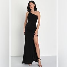 a woman in a black one - shoulder dress posing with her legs slited up