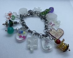 This is a one-of-a-kind handmade charm bracelet.  It features original charms, including ones of resin and shrinky dink.  The entire bracelet is handmade and is the only one of its kind.  Although similar ones can be made, this is truly an original one-of-a-kind masterpiece. The entire bracelet length is 8 inches long and features a lobster claw fastener with some room to make either larger or smaller, depending on wrist size. Priority shipping is free if shipped in the United States. Playful Handmade Silver Charm Bracelet, Playful Handmade Silver Bracelets, Unique Nickel-free Charm Bracelet As Gift, Handmade Clear Bracelets As Gifts, Handmade Clear Bracelets For Gifts, Handmade Clear Bracelets As A Gift, Handmade Clear Beaded Bracelets As Gift, Handmade White Fun Charm Bracelet, Whimsical Handmade White Charm Bracelet