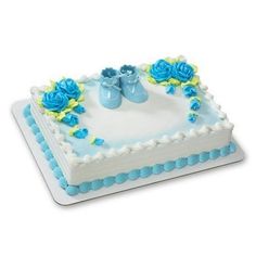 a white cake with blue flowers and baby shoes on it