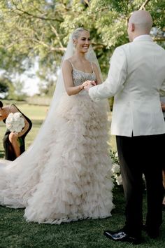 a bride and groom standing in front of each other