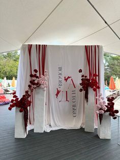 a white and red decorated stage with flowers on it