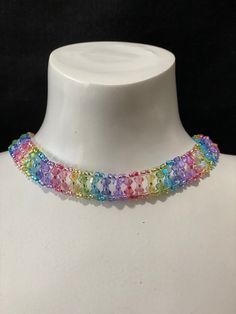 a white mannequin wearing a multicolored necklace