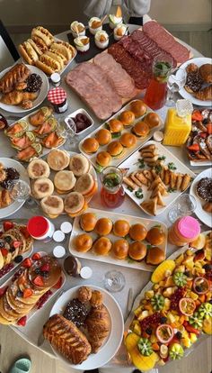 a table filled with lots of different types of food on plates and trays next to each other