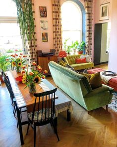 a living room filled with lots of furniture and flowers in vases on the table