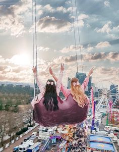 a woman sitting in a hammock suspended over a fairground with her hands up