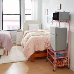 a bedroom with two beds, a tv and a pink cart in front of the window