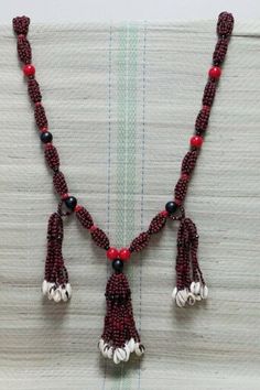 This collar is made with 6mm and 20mm red and black glass beads, and finished with shells.  Each bead is hand strung on heavy duty special nylon string making this collar strong and durable.  This collar de mazo is beautifully done. The handmade collar is a special tribute to Elegua de cabezera. Traditional Red Necklaces With Black Beads, Traditional Red Necklace With Black Beads, Artisan Red Beaded Necklace With Black Beads, Artisan Red Jewelry With Black Beads, Red Handwoven Beads For Jewelry Making, Traditional Handmade Red Coral Beads, Adjustable Red Beaded Necklace With Black Beads, Handwoven Red Beads For Festival, Red Handwoven Beads For Festival