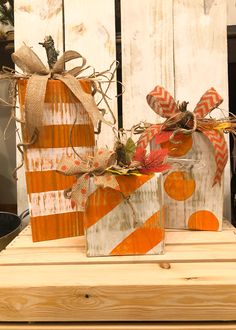 two wooden pumpkins decorated with bows and twine