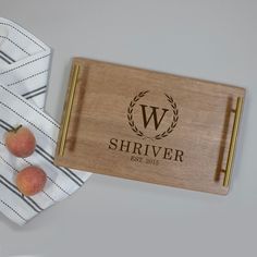 a personalized cutting board with two peaches on it and a striped napkin next to it