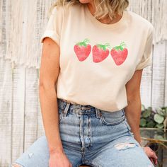 Womens strawberry shirt Cottagecore T shirts Cute Strawberry Shirt Womens Cottagecore Tops Watercolor T Shirt Grandmacore Fashion Fruit Shirt Cottagecore Style Botanical Shirt Printed tee Graphic Tee. Womens strawberry shirt // Cottagecore style // Cottagecore shirt // Cottagecore T shirts // Farmers Market Our T-shirts are made of ring spun cotton that create a soft feel.  For an Oversized look, order 2-3 sizes bigger than your normal size. Check out sizing chart in pictures.  ❤ About our T shirts + Soft cotton  + Unisex jersey short sleeve tee + Crew neck  + Designed with love in Canada, printed and shipped from the US + Run true to size ❤ CARE INSTRUCTIONS Wash with like colors, in cold water, on gentle cycle. Tumble dry on low or air dry. Do not use and iron directly on design.  ❤ SHIP Sweet Summer Tops With Fruit Print, Sweet Fruit Print Summer Tops, Sweet Fruit Print Tops For Summer, Sweet Strawberry Print Crew Neck Top, Cute Cotton Tops With Fruit Design, Sweet Short Sleeve Tops With Fruit Print, Casual Cotton Tops With Fruit Design, Casual Cotton Top With Fruit Design, Trendy Red T-shirt With Strawberry Print