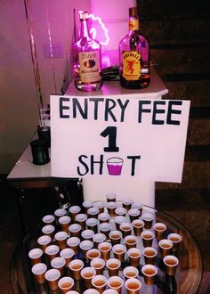 there is a sign that says entry fee 1 shot with cups in front of it