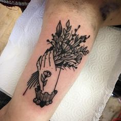 a black and white photo of a person holding flowers on their arm, with the word love written below it