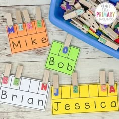 wooden clothes pegs with letters and numbers on them in front of a blue tray