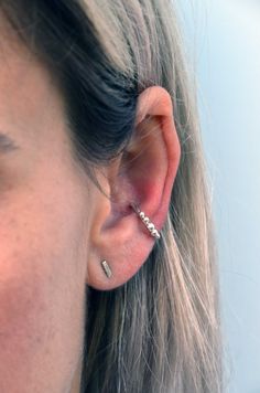 a close up of a person wearing an ear piercing