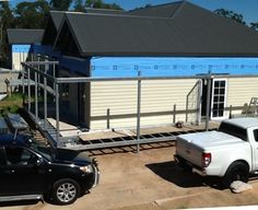 two trucks parked in front of a house under construction