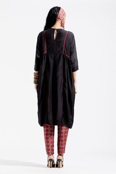 Black kurta with embroidered yoke, featuring resham thread embroidery with sequins, cowry shells and tassel embellishments and contrast seam inserts. Paired with printed narrow trouser.
Component: 2
Embroidered, Printed
Neckline: Round
Sleeve Length: Three Quarter
Fabric: Kurta: Cotton Silk; Trouser: Cotton 
Color: Black, Red
Side gathering panel
Back keyhole closure
Back elasticated trouser
Note: The stole and top worn by the model is for styling purpose only - Aza Fashions Designer Kurta With Yoke For Eid, Festive Cotton Silk Kurta With Yoke Detail, Festive Cotton Silk Kurta With Yoke, Festive Chanderi Kurta With Yoke Detail, Anarkali Chanderi Kurta With Yoke Detail, Festive Kurta With Yoke Detail, Transitional Festive Kurta With Yoke, Eid Anarkali Kurta With Yoke Detail, Festive Transitional Yoke Kurta