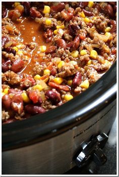 a crock pot filled with chili and corn