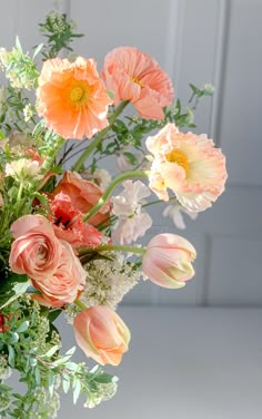 a vase filled with lots of different colored flowers