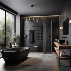 a large black bath tub sitting next to a walk in shower