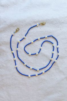 "Versatile chain for glasses / sunglasses that doubles as a necklace and mask chain. Designed and crafted for daily wear. This chain is super special! It has a dainty, delicate feel and can easily be dressed up or down.  - Made with opaque, matte finish Japanese beads in gorgeous, vibrant royal blue - White and yellow Czech glass bead daisies are grouped into threes. (Makes a cute pattern when wrapped into a necklace.) - 18k gold-plated hardware - Double strung on the strongest and most flexible beading thread for exceptional durability and drape (no stretch, no crimping)  - 24\" length   Production time is approx 3 days plus shipping. Rush production and rush shipping available as a shipping upgrade at checkout. Please see other listings for more styles. Message for custom option." Blue Glasses Chains With Colorful Beads For Beach, Blue Beaded Glasses Chain For Beach, Dainty Blue Necklaces For Summer, Blue Glasses Chains For Beach Summer, Blue Glasses Chains For Summer Beach, Blue Glasses Chains For Beach In Summer, Blue Beaded Chain Glasses Chains With Round Beads, Blue Beaded Glasses Chains, Blue Glasses Chain With Colorful Beads As Gift