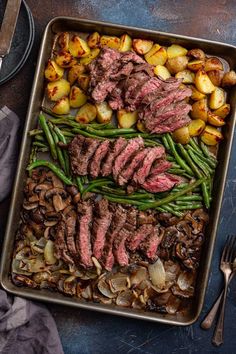 a pan filled with steak, potatoes and green beans