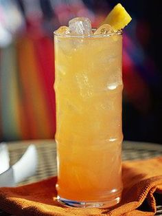 a tall glass filled with lemonade sitting on top of a table