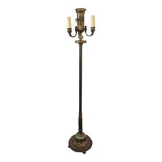 an old fashioned floor lamp with two candles