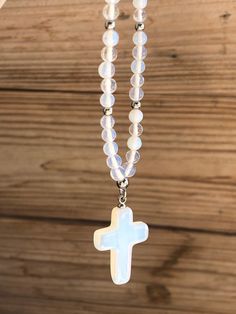 "Moonstone cross car mirror charm - Car protection This mirror jewel is made of a moonstone cross and beads. Materials : - 4mm or 6mm round moonstone beads - Moonstone cross charm 25 x 16mm - Stainless steel lobster clasp - Length : 15 cm - 6 inches approx. The first picture shows a mirror charm made with 4mm beads size. Moonstone properties : A stone for \"new beginnings\", Moonstone is a stone of inner growth and strength. It soothes emotional instability and stress, and stabilises the emotion White Spiritual Crucifix Cross Necklace, White Crucifix Cross Necklace, Moonstone Properties, Car Mirror Charm, Car Protection, Car Charms Mirror, Moonstone Beads, Car Charms, Cross Charms