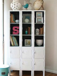 a white bookcase filled with books on top of a hard wood floor