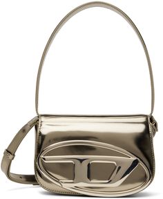 Structured patent leather top handle bag in metallic beige. · Fixed carry handle · Detachable and adjustable shoulder strap · Logo hardware at face · Concealed patch pockets at face · Foldover flap with magnetic press-stud closure · Patch pocket at interior · Twill lining in black · H5 x W8 x D2.25 in Supplier color: Bronze