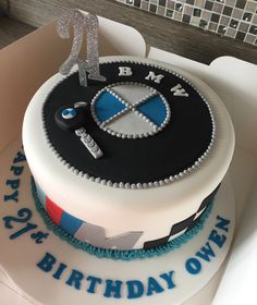 a birthday cake with the number twenty one on it and an automobile emblem is shown