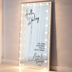 a lighted mirror with the words hello dolly written on it in front of a curtain