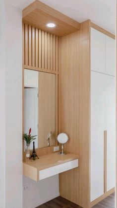 a bathroom with a sink, mirror and cupboards in the corner next to each other