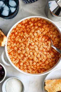 an overhead view of a bowl of macaroni and cheese with bread on the side