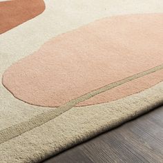 a close up of a rug on a wooden floor with an oval design in the middle