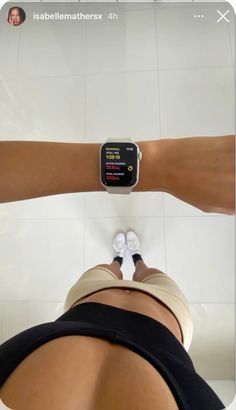 a person standing in front of a white tiled wall with an apple watch on their arm