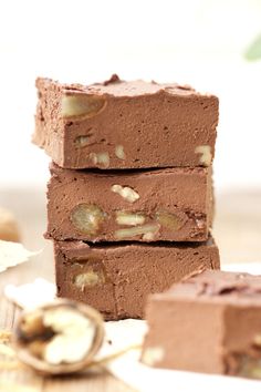 three pieces of chocolate fudge cake stacked on top of each other with nuts in the middle