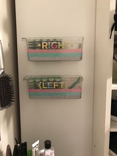 two clear containers are hanging on the wall next to a hairdryer and brush