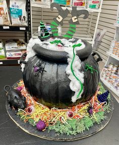 a halloween themed cake in the shape of a witch's caulder on display