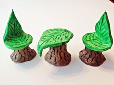 three small green plants sitting on top of rocks