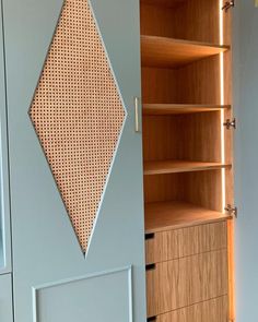 a cabinet with some drawers in it next to a wall mounted shelf and cupboards