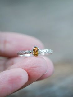 This oval citrine ring rings in a festive and glowing spirit. Set in a bezel setting with a vibrant yellow-orange citrine sourced from Brazil. The silver band has a hammered texture, which adds both shine and dimension. Citrine is a November birthstone. Each piece of our jewelry is handcrafted with love. This rustic citrine ring will add a touch of festivity to your everyday look. Amber Topaz Sterling Silver Promise Ring, Amber Topaz Ring In Sterling Silver For Promise, Sterling Silver Amber Birthstone Rings, Amber Topaz Sterling Silver Ring, Silver Citrine Birthstone Ring Gift, Orange Citrine, Ring Birthstone, Gold And Silver Rings, Ethical Jewelry