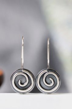 "These earrings are part of my spiral series. They are handcrafted of sterling silver with sturdy 19 gauge ear wires that clip securely in the back. They measure 5/8\" in diameter and about 1 1/8\" in length, and have a bright, shiny finish. I will ship these earrings via USPS First Class Mail within 3-5 days of receipt of payment." Handmade Silver Swirl Earrings, Handmade Swirl Earrings As Gift, Handmade Artisan Spiral Earrings, Handmade Swirl Earrings For Gifts, Unique Handmade Spiral Earrings, Spiral Earrings With Ear Wire As Gift, Spiral Earrings With Ear Wire For Gifts, Unique Spiral Ear Wire Earrings, Unique Swirl Earrings As Gift