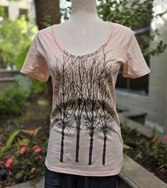 This lightweight Rosé pink scoop neck tee is made from 100% organic cotton for the everyday wear. Each tee is unique with black trees design screen print. A relaxed fit, wear it with your favorite jeans, shorts or skirt. Tee size Small (S) shown on dressmaker dummy size US 6. Accessories not included. Sustainably made in the USA. Brand new and ready to wear upon arrival. FREE US shipping. - 100% Organic Cotton - GOTS Certified Organic Cotton - US size: Small (2-4), Medium (6-8), Large (10-12) - Scoop neck  - Tee length approx. 25" from shoulder to hem - Hand or machine wash cold water with like colors - Made in USA AKO wear residual merchandise post business closure. See more items on sale by seller. Hand Dyed Pink Cotton T-shirt, Pink Cotton T-shirt With Plant Print, Pink Cotton Scoop Neck T-shirt, Pink Stretch T-shirt With Scoop Neck, Pink Organic Cotton Crew Neck T-shirt, Black Tree, Scoop Neck Tee, Tree Designs, Favorite Jeans