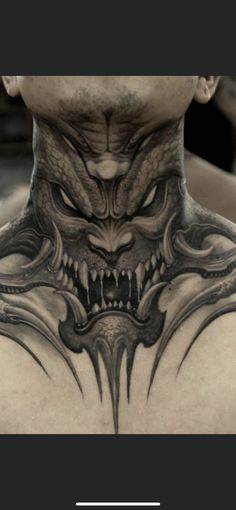 the back of a man's neck with an evil face and demon head on it