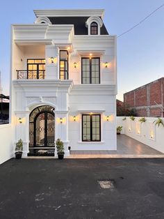 a white two story house with lots of windows and balconies on the second floor