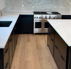 a kitchen with an oven, stove and counter tops in white marble tiles on the backsplash