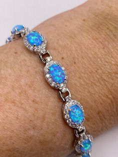 Vintage Blue Fire Opal Cubic Zirconia Bracelet inlay 925 Sterling Silver This genuine Opal  bracelet is very lively and bright.   The stones are deep colors and well matched.   The sterling silver is plated with rhodium to protect the bracelet from tarnish 7.5 in My jeweler can shorten it for a $20 fee.  All jewelry is shipped free in the US in a nice gift box.   Check out our over a THOUSAND great reviews Engraving is $4 per letter and is not always perfect depending on the piece. It can take a Oval Blue Sterling Silver Bracelet As Gift, Oval Blue Sterling Silver Bracelet Gift, Blue Oval Sterling Silver Bracelet Gift, Blue Cubic Zirconia Sterling Silver Bracelet Gift, Blue Fire Opal, Cubic Zirconia Bracelet, Opal Bracelet, Blue Fire, Deep Colors